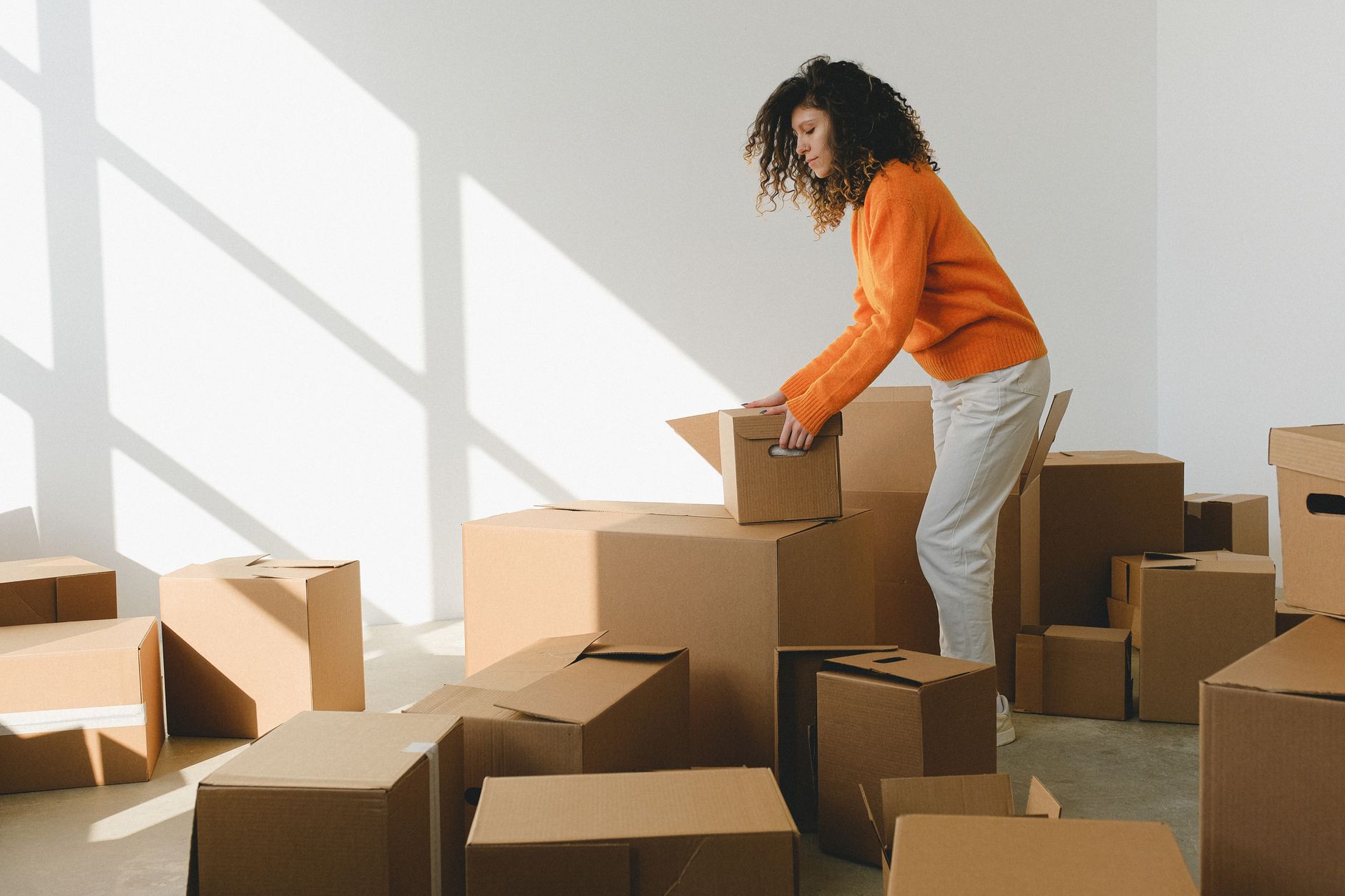 Persona organizando cajas al mudarse a un nuevo departamento